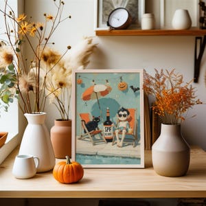 May include: A framed print depicts a beach scene with a person in sunglasses, a black cat, and a bottle of SPF 10,000. The image is set against a light blue background with Halloween decorations. A small orange pumpkin sits on a wooden surface.