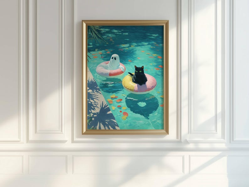 Op de afbeelding: Ingelijste kunstdruk met een zwarte kat en een geest die in een zwembad op opblaasbare ringen drijven. Het zwembadwater is turquoise, met kleurrijke vissen en reflecties. Het kunstwerk is ingelijst in een goudkleurige lijst.
