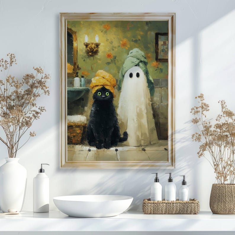 May include: A framed painting depicts a black cat and a ghost in a bathroom setting. The cat wears a yellow towel on its head, and the ghost is draped in a white sheet. The bathroom has floral wallpaper and a mirror.