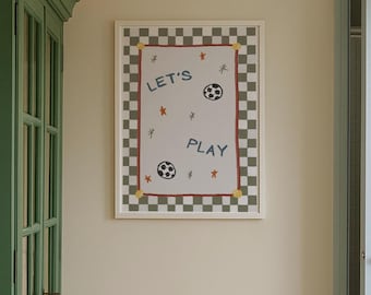 Puede incluir: Un póster enmarcado con fondo blanco con las palabras "LET'S PLAY" en azul, junto con dos balones de fútbol e ilustraciones de estrellas. El póster tiene un borde a cuadros en verde y blanco, con un borde interior rojo y detalles dorados.
