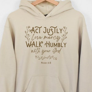May include: Beige hoodie with a brown graphic print that reads "Act justly, love mercy, walk humbly with your God, Micah 6:8".