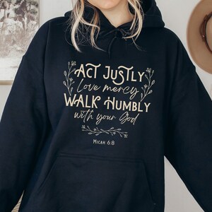 May include: Black hooded sweatshirt with the text "Act justly, love mercy, walk humbly with your God" and "Micah 6:8" in a cream color font.
