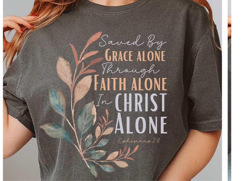 May include: A dark grey t-shirt with a floral design and the text "Saved By Grace Alone Through Faith Alone In Christ Alone Ephesians 2:8".