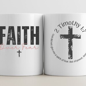 May include: White ceramic mug with a black and white design. The front of the mug says "FAITH Over Fear" with a small cross. The back of the mug says "2 Timothy 1:7 God did not give me a spirit of fear. But of power, love, and a sound mind."