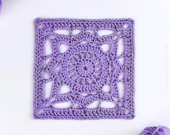 May include: A square, lavender crochet doily with an openwork floral design. The center features a spiral pattern, surrounded by intricate lace-like details. The doily is surrounded by a solid border. The image includes a ball of lavender yarn.