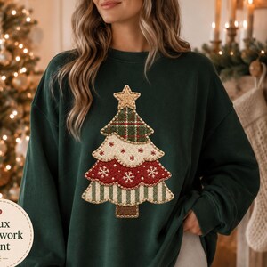 May include: A forest green long-sleeve sweatshirt featuring a central graphic of a Christmas tree with a faux patchwork print. The tree design consists of four horizontal layers with varied patterns including plaid, snowflakes, and stripes, topped with a star.