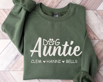May include: Green sweatshirt with the text "Dog Auntie" and the names Clem, Hanni, and Bells printed in white.