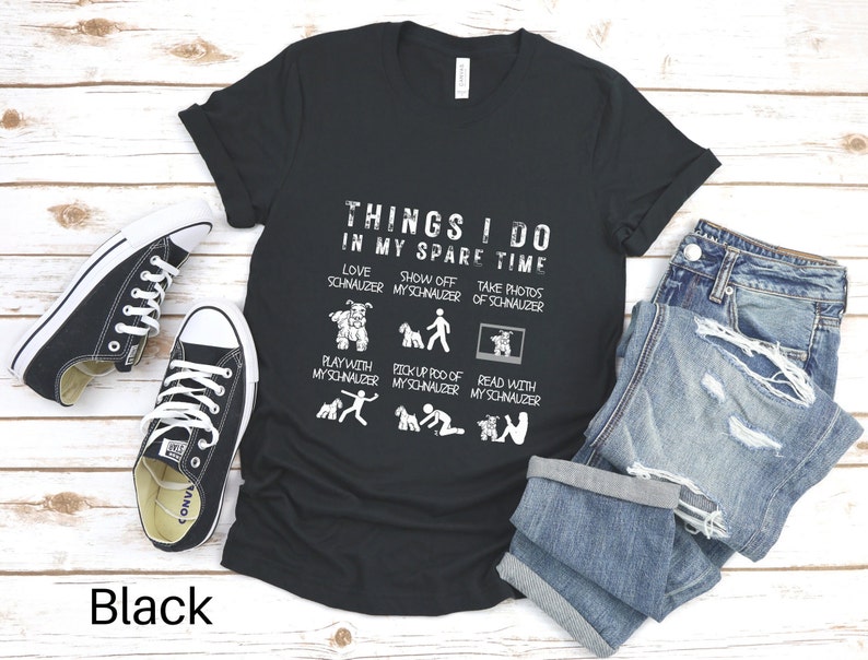 May include: Black t-shirt with a white graphic that says "Things I do in my spare time" and lists activities related to owning a schnauzer. The graphic includes illustrations of a schnauzer.