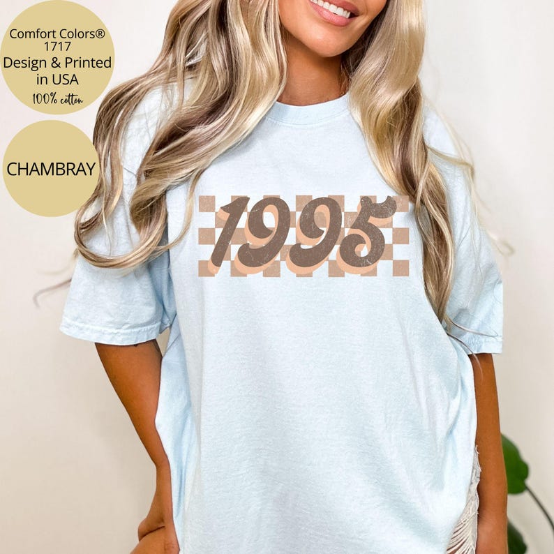 May include: A light blue t-shirt with a brown and white checkered pattern and the number 1995 in brown text.