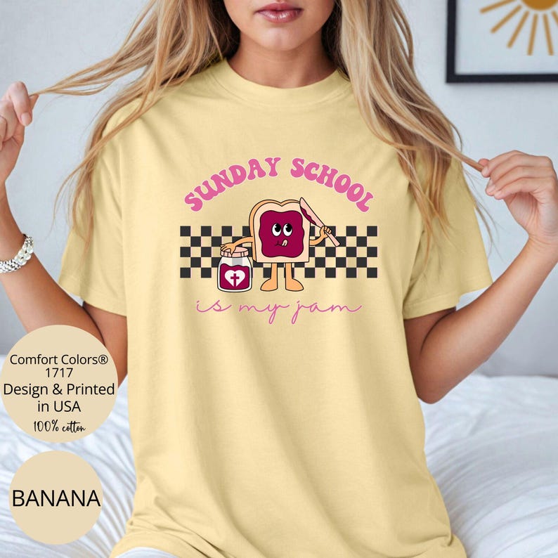 May include: A yellow t-shirt with a graphic of a cartoon slice of bread with a face and a jar of jam. The text "SUNDAY SCHOOL is my jam" is printed on the shirt.
