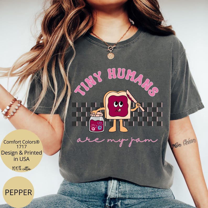 Pu&ograve; includere: T-shirt Comfort Colors grigio scuro con la scritta rosa "TINY HUMANS are my jam". La grafica presenta un toast dei cartoni animati con marmellata, un barattolo di marmellata e un coltello. La maglietta &egrave; 100% cotone e stampata negli Stati Uniti.