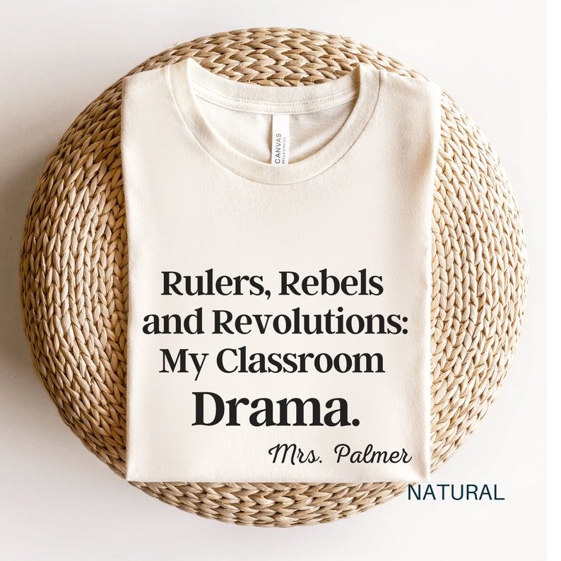 Peut inclure: Un t-shirt blanc avec le texte "Rulers, Rebels and Revolutions: My Classroom Drama. Mrs. Palmer" imprim&eacute; en noir.