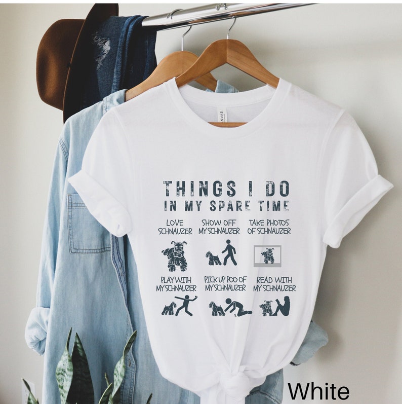 May include: White t-shirt with a graphic design that says "Things I do in my spare time" and lists activities related to owning a Schnauzer dog. The activities include: love Schnauzer, show off my Schnauzer, take photos of Schnauzer, play with my Schnauzer, pick up poo of my Schnauzer, and read with my Schnauzer.