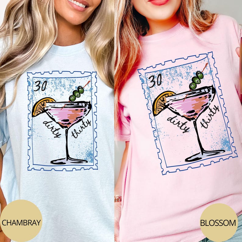 May include: Light blue and pink t-shirts with a cocktail graphic. The graphic is a stamp design with a pink martini, olives, and a lemon slice. The text on the stamp reads "30" and "dirty thirty". The bottom of the shirts read "CHAMBRAY" and "BLOSSOM".