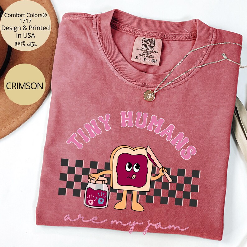 Pu&ograve; includere: T-shirt Comfort Colors color cremisi con la scritta "TINY HUMANS are my jam" e un'immagine a cartoni animati di pane tostato con marmellata. La maglietta &egrave; 100% cotone e progettata e stampata negli Stati Uniti.