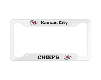 May include: White plastic license plate frame with the Kansas City Chiefs logo and the text "Kansas City Chiefs".