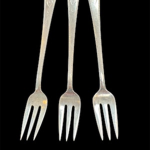 May include: A set of three ceramic mugs with a speckled, matte finish. The mugs are in shades of cream, light gray, and dark gray. Each mug has a simple, minimalist design, perfect for coffee or tea.