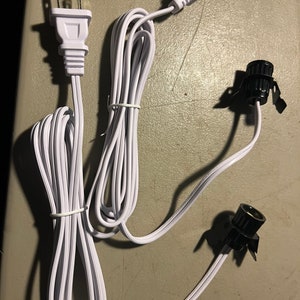 May include: Two white electrical cords with US standard plugs and black lamp sockets.