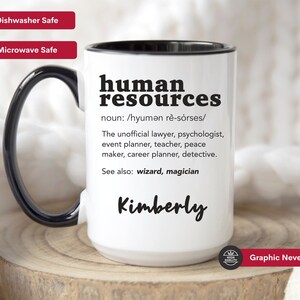 May include: White ceramic mug with a black rim and handle. The mug features a black graphic that says "human resources" with a definition and the name "Kimberly". The mug is dishwasher and microwave safe.