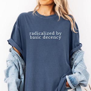 Op de afbeelding: Een oversized navyblauw t-shirt met de tekst "geradicaliseerd door elementaire fatsoen" in wit gedrukt.