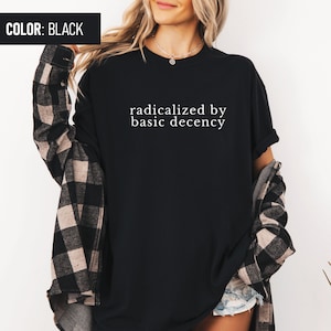 Op de afbeelding: Zwart T-shirt met de tekst "radicalized by basic decency" in wit.