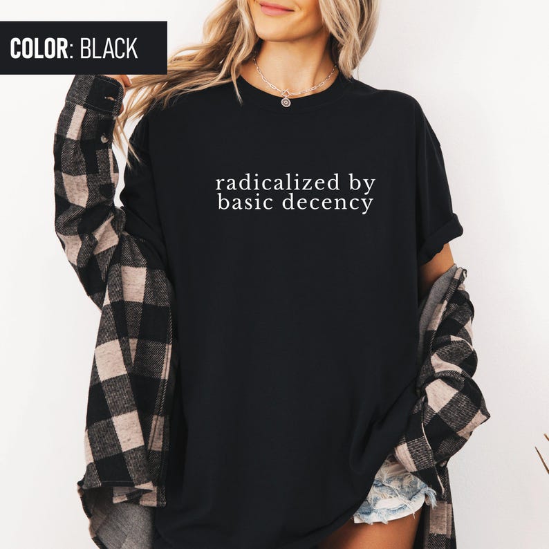 Op de afbeelding: Zwart T-shirt met de tekst "radicalized by basic decency" in wit.