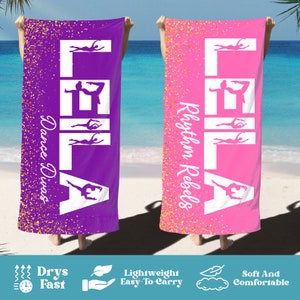 May include: Two purple and pink beach towels with gold glitter. The towels feature the name "LEILA" in white with a silhouette of a dancer in each letter. One towel says "Dance Divas" and the other says "Rhythm Rebels".