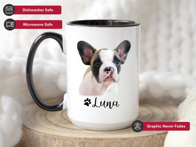 Op de afbeelding: Een witte keramische mok met een zwarte rand en handvat. De mok heeft een kleurrijke illustratie van een Franse bulldog puppy met de naam "Luna" eronder gedrukt. De tekst "Graphic Never Fades" staat gedrukt op de onderkant van de mok.