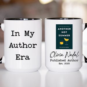 May include: White ceramic mug with black handle and rim. One side reads "In My Author Era." The other side features a book cover design for "Another Hot Summer" by Olivia Nadal, published in 2025. A literary-themed gift.