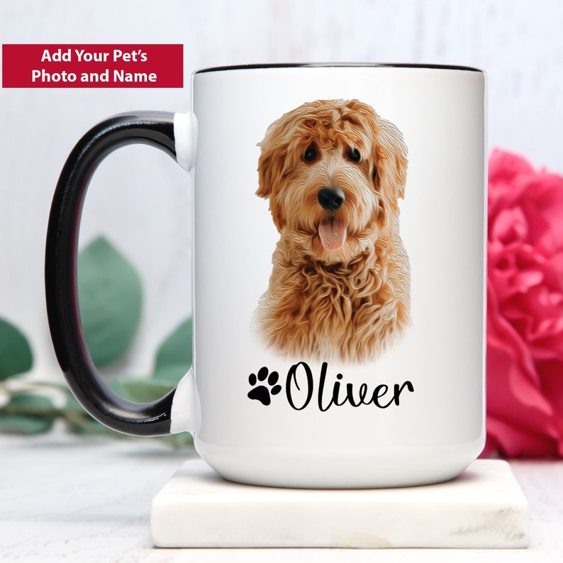 Op de afbeelding: Witte keramische koffiemok met een zwarte handgreep en rand. De mok heeft een foto van een golden doodle hond met de naam "Oliver" onder de afbeelding.