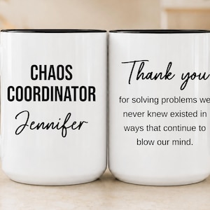 May include: A white ceramic mug with a black handle and rim. The front features the text "CHAOS COORDINATOR" in bold black letters above the name "Jennifer" in script. The back displays the text "Thank you for solving problems we never knew existed in ways that continue to blow our mind."
