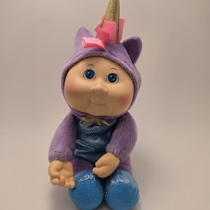 May include: A white ceramic mug with a black handle and the text "But First, Coffee" in a handwritten style. The mug is on a white surface. The mug is 4 inches tall.