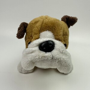 May include: A brown and white plush bulldog toy with brown ears. The toy has a white face with a black nose and black eyes.