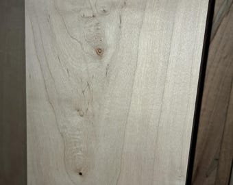 May include: A close-up of a light wood panel with a natural grain pattern. The wood has a light brown color and a smooth surface.