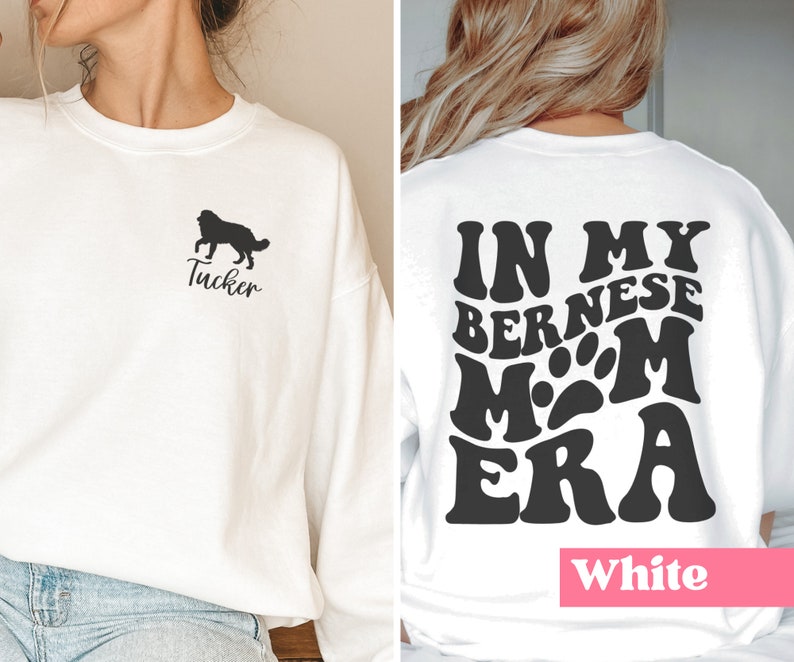 May include: White sweatshirt with a black silhouette of a dog and the name "Tucker" on the front. The back of the sweatshirt has the text "In My Bernese Mom Era" in a retro font.