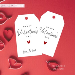 May include: Two white gift tags with the text "Happy Valentines Day" and a small red heart. The text "Love. Mark" is written on the left tag. The tags are on a red background.