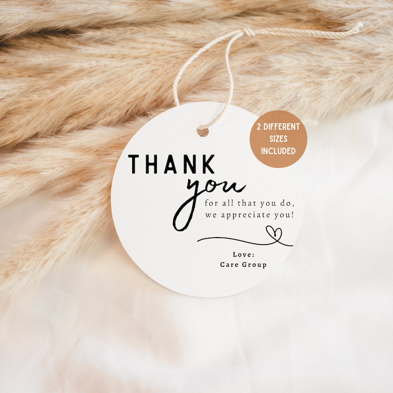 May include: White round thank you tag with black text that reads "THANK you for all that you do, we appreciate you!" with a small heart symbol and the text "Love: Care Group". The tag has a brown circle with the text "2 DIFFERENT SIZES INCLUDED".