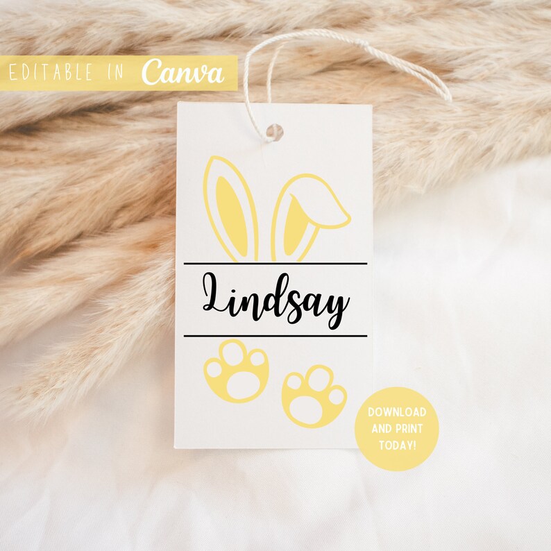 May include: A white tag with a yellow bunny ear design, the name "Lindsay" in black text, and two yellow paw prints. The tag has a yellow circle with the text "Download and Print Today!"