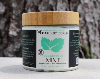 Puede incluir: Un tarro de 700 ml de exfoliante corporal vegano de menta y eucalipto de la colección Lauren Paige. El tarro es de vidrio transparente con tapa de bambú. La etiqueta es blanca con texto negro y un diseño de hojas verdes. El texto de la etiqueta dice "Exfoliante corporal vegano", "Menta y eucalipto", "Una limpieza natural para el cuidado de la piel", y "16 oz / 700 ml / 30% ALC".