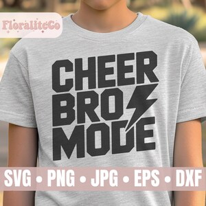 Op de afbeelding: Een lichtgrijs t-shirt met de tekst "CHEER BRO MODE" in vette zwarte letters en een bliksemflits. De onderkant van het shirt toont "SVG • PNG • JPG • EPS • DXF" in een lichtroze banner.