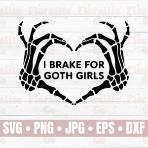 May include: A black graphic design featuring two skeletal hands positioned to form a heart shape. Centered between the hands is the text I BRAKE FOR GOTH GIRLS in a bold, sans-serif font. The design is presented against a white wood background.