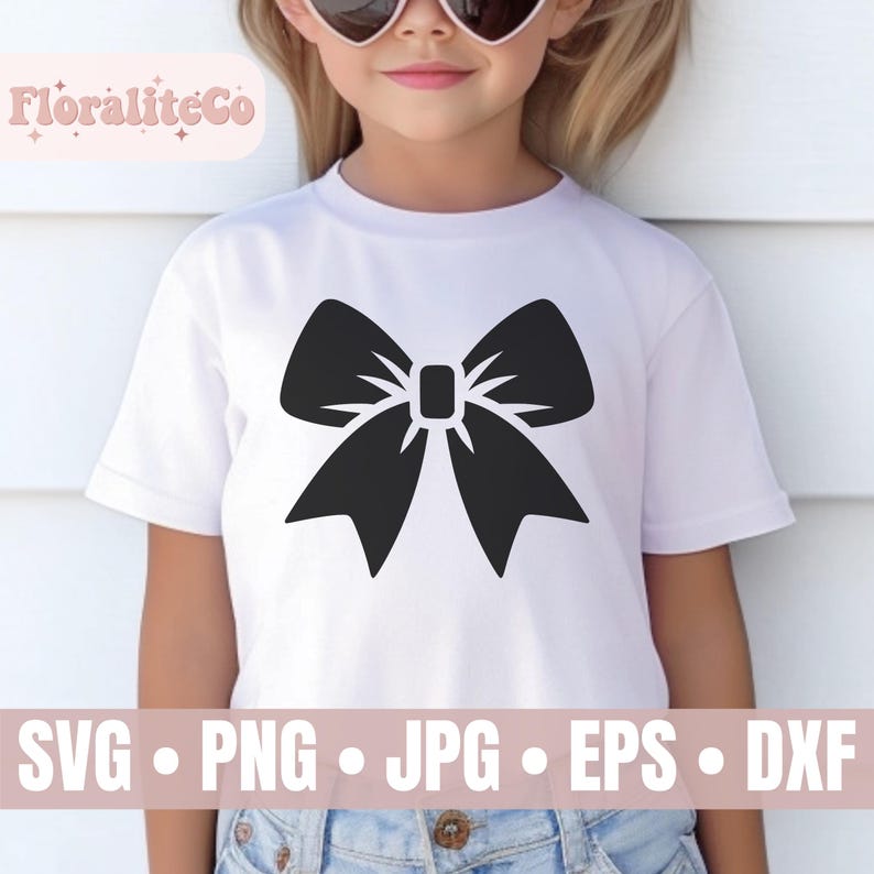 Op de afbeelding: Een wit T-shirt met een zwart strikdesign. Het shirt wordt gedragen door een kind. De tekst "FloraliteCo" is zichtbaar in de linkerbovenhoek van de afbeelding.