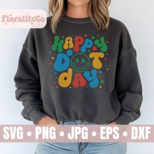 May include: Dark gray sweatshirt with the words "Happy Dot Day" in colorful bubble letters and a smiley face. The sweatshirt has a vintage, washed look. Below the design are the file types: SVG, PNG, JPG, EPS, and DXF.