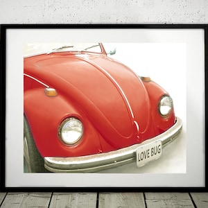 Könnte beinhalten: Nahaufnahme eines roten Volkswagen Käfers mit einem weißen Streifen auf der Motorhaube. Das Auto hat eine Chromstoßstange und ein Nummernschild mit der Aufschrift "LOVE BUG".