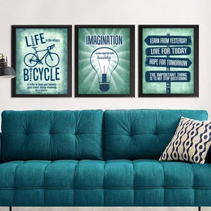 Pode incluir: Três quadros emoldurados com citações inspiradoras. O primeiro apresenta uma bicicleta e o texto "A vida é como andar de bicicleta, para manter o equilíbrio é preciso continuar a andar." O segundo diz "A imaginação é mais importante que o conhecimento." O terceiro diz "Aprenda com o ontem, viva o hoje, espere o amanhã."