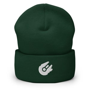 Könnte beinhalten: Eine dunkelgrüne Mütze mit einem weißen, gestickten Raumschiff-Design.