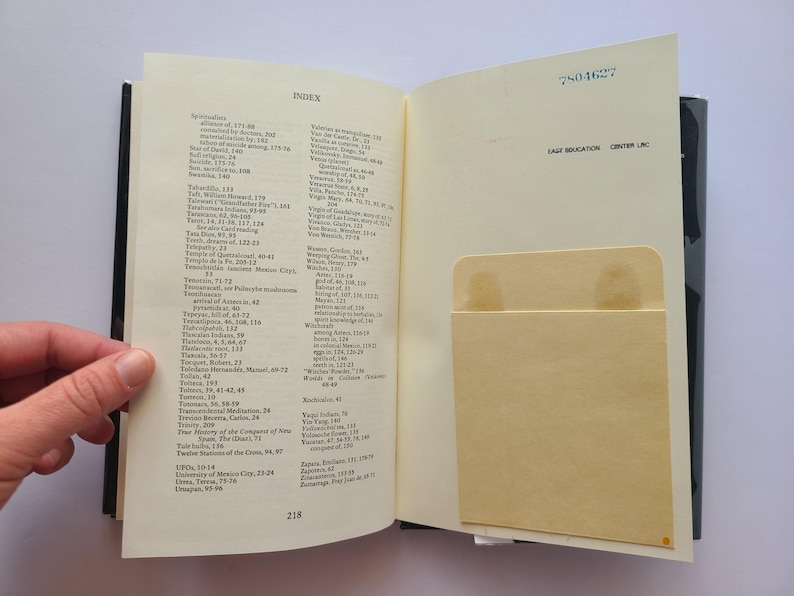 Pu&ograve; includere: Libro aperto che mostra una pagina indice con un elenco di argomenti e numeri di pagina. Una tasca color beige chiaro &egrave; visibile sulla pagina di destra. Il libro &egrave; aperto, rivelando l'indice e una tasca. Il dorso del libro &egrave; nero.