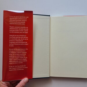 Puede incluir: Un libro rojo con una columna vertebral blanca y una p&aacute;gina blanca abierta para revelar una p&aacute;gina en blanco. La portada del libro tiene texto sobre Franz Bandon, un adepto herm&eacute;tico, y su vida y obra.