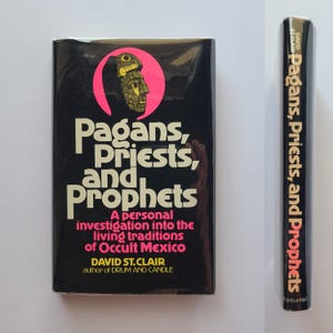 Pu&ograve; includere: Un libro vintage intitolato "Pagans, Priests, and Prophets" di David St. Clair. La copertina &egrave; nera con testo bianco e rosa e una grafica di un volto all'interno di un cerchio rosa. Anche il dorso mostra il titolo.