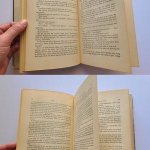 May include: An old book with yellowed pages, held open to reveal printed text. The pages are being held open by a hand. The book's spine is visible, and the text appears to be a narrative.